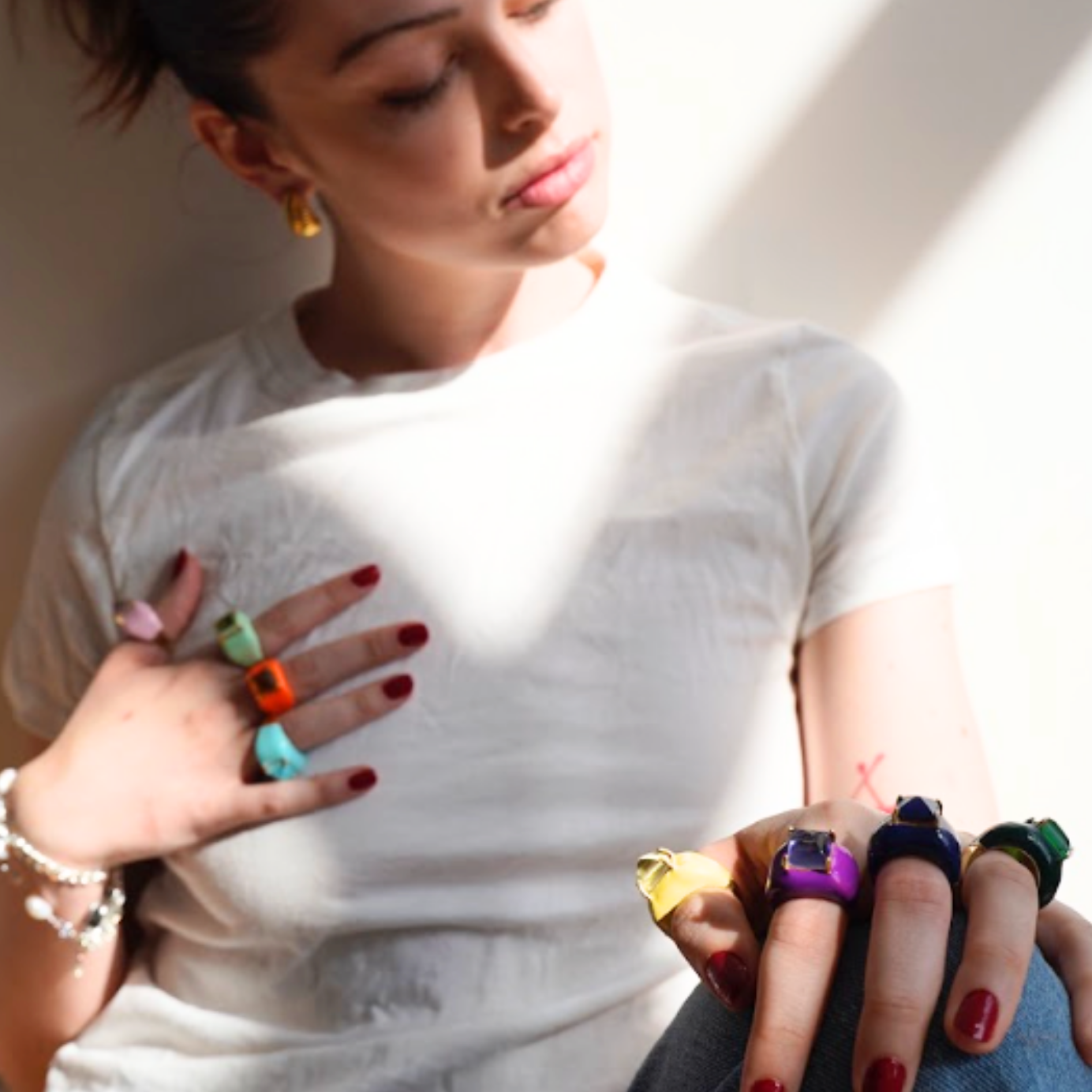 Woman wearing multiple colorful rings on her fingers