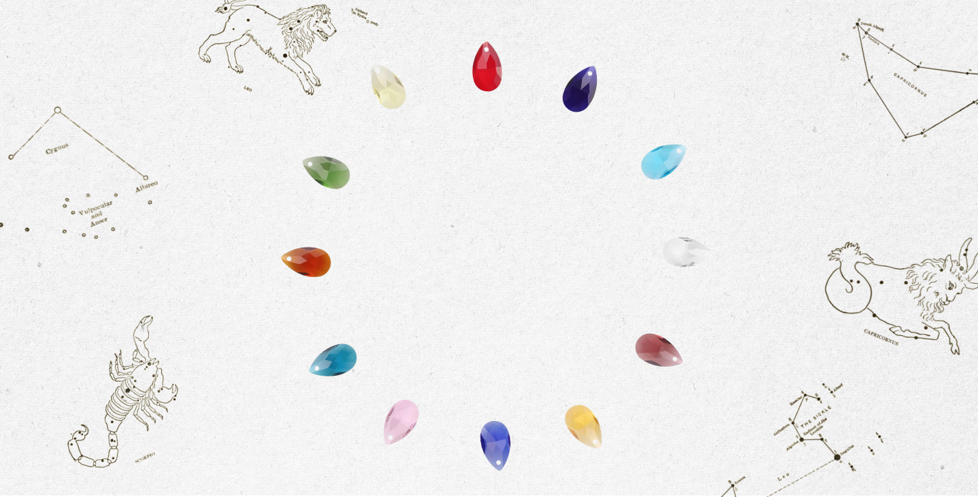 Colorful gemstones arranged between zodiac signs on a white background